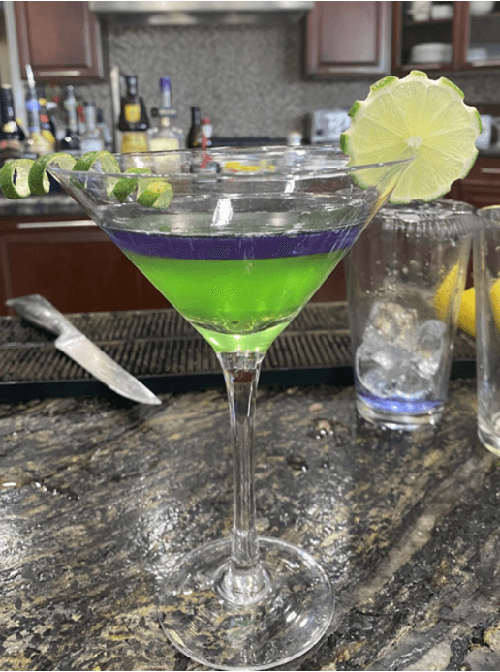 Bright blue and neon green layered cocktail in a martini glass at a casino party in Mesquite, TX