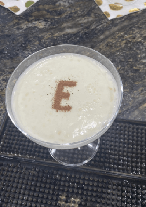 Signature cocktail created for event with the letter E in cinnamon, on top of foam in a martini glass
