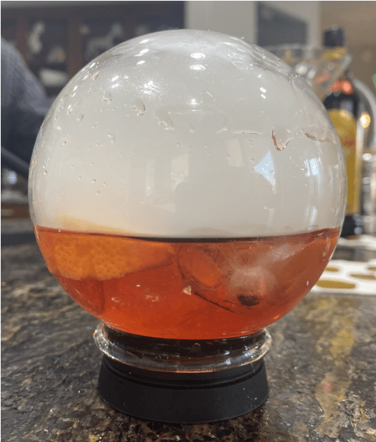 Original recipe cocktail in a round glass that looks like a fishbowl