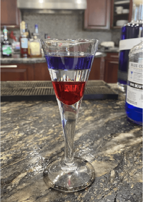 Beautiful layered cocktail with red, white, and blue