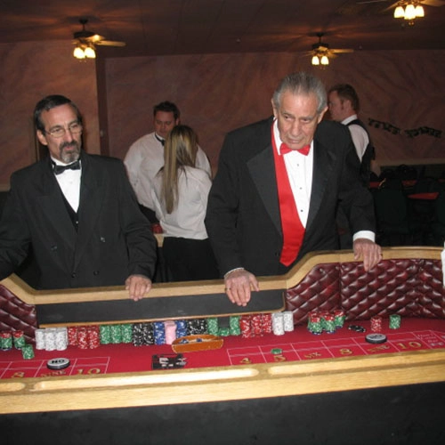 Men in tusedos playing Roulette at a casino themed birthday party.