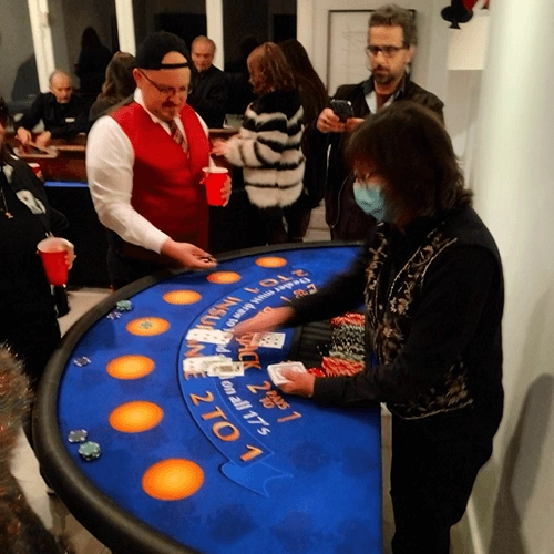 Happy casino event guests playing blackjack.