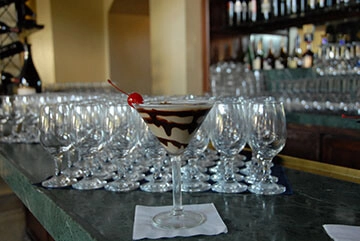 Wine glasses over a bar for a beverage catering service.